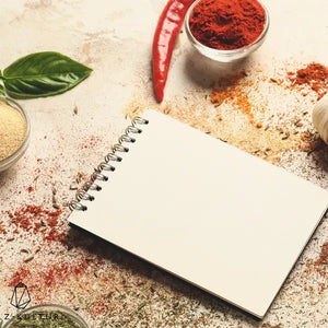 Gewürze auf einem Tisch neben einem Notizblock - Rezepte & Wissen
