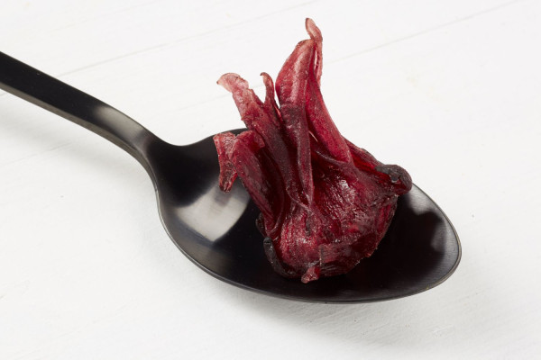 Kandierte Hibiskusblüte auf schwarzem Löffel